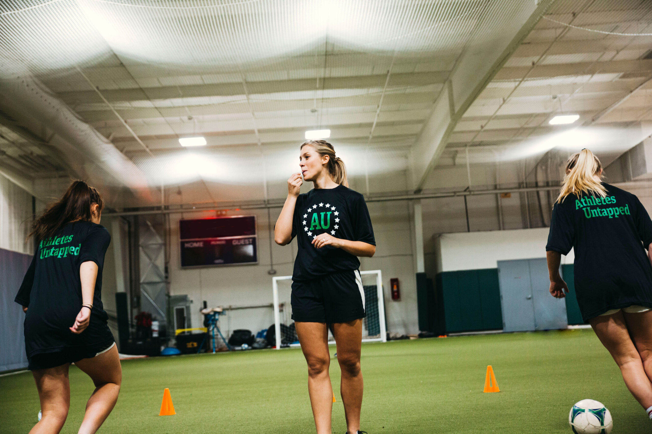 Private soccer coach teaching drills with cones during group lesson