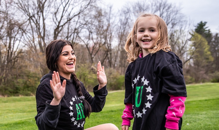 Private softball coach celebrating with a young athlete during lesson