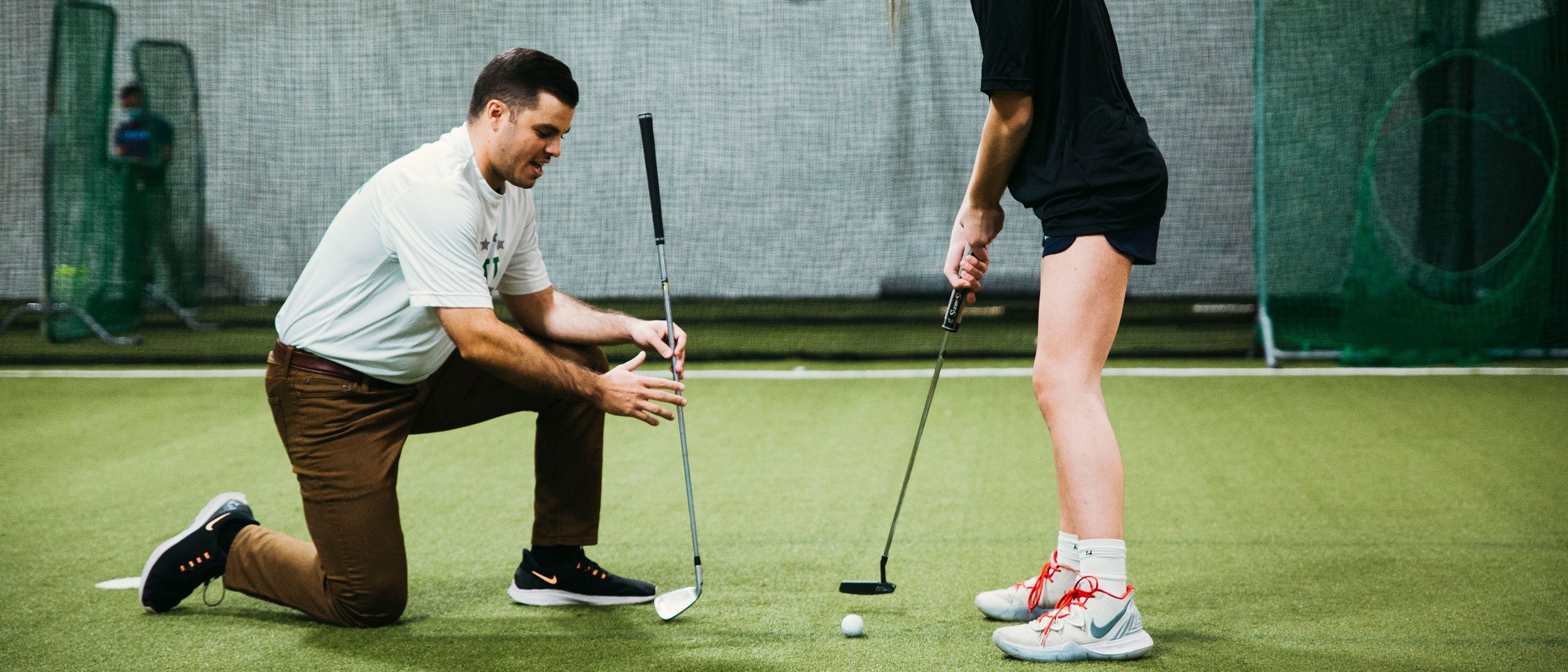 Private golf coach teaching young athlete during lesson