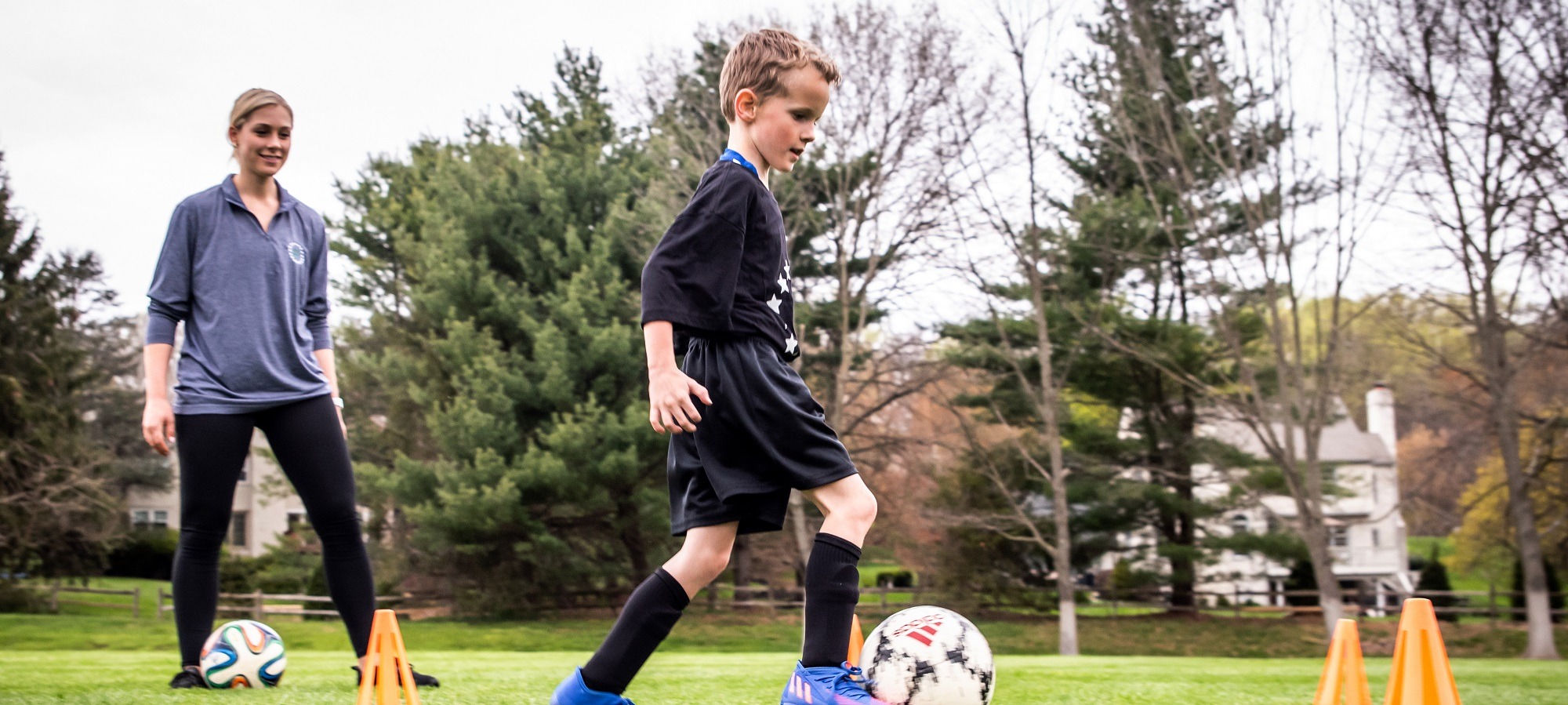 Private soccer coach teaching young athlete during lesson